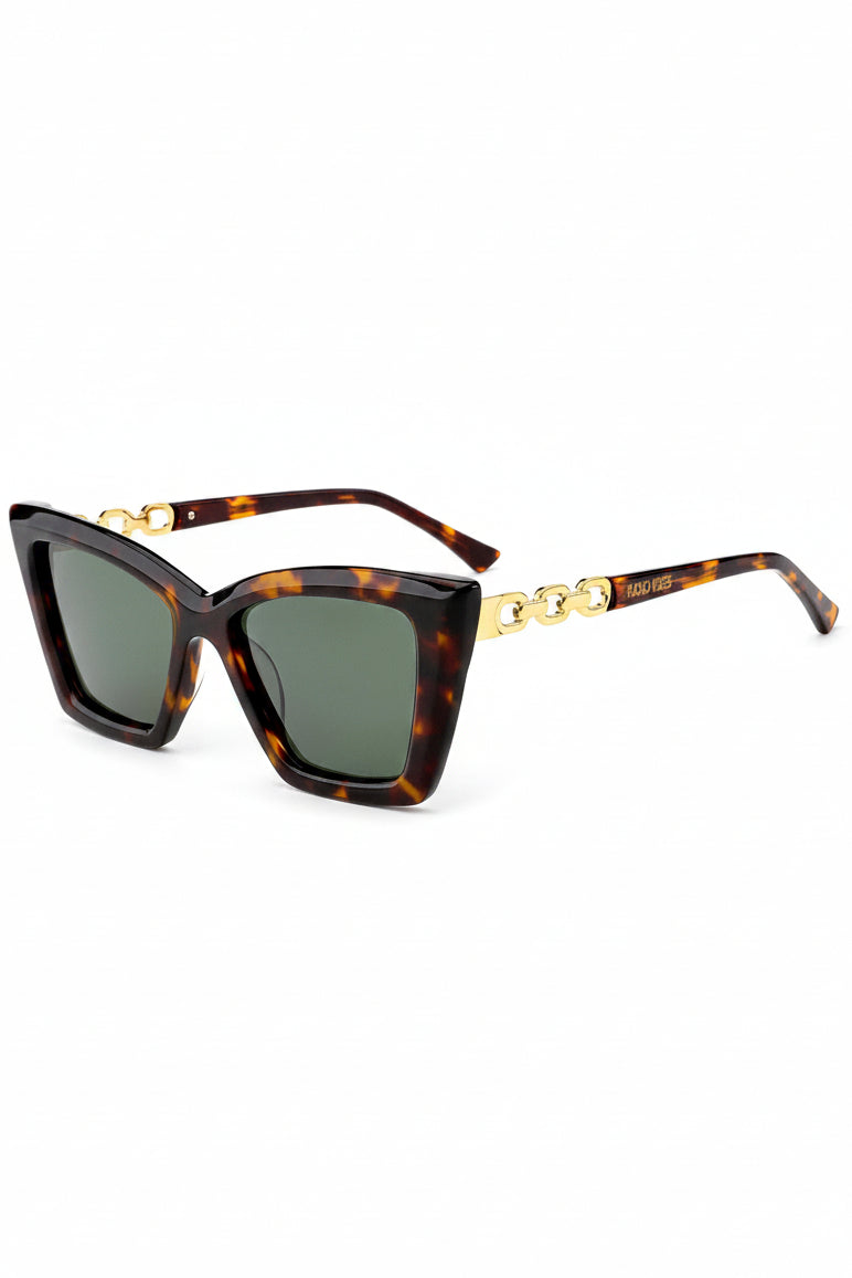 aurora cat eye turtoise mønster solbrille fra Fjord Vibes of Norway med gulldetaljer på armen og klassisk skilpaddemønster i svart og brun. Solbrillen har glass i grå- brune toner og turtoise ramme.