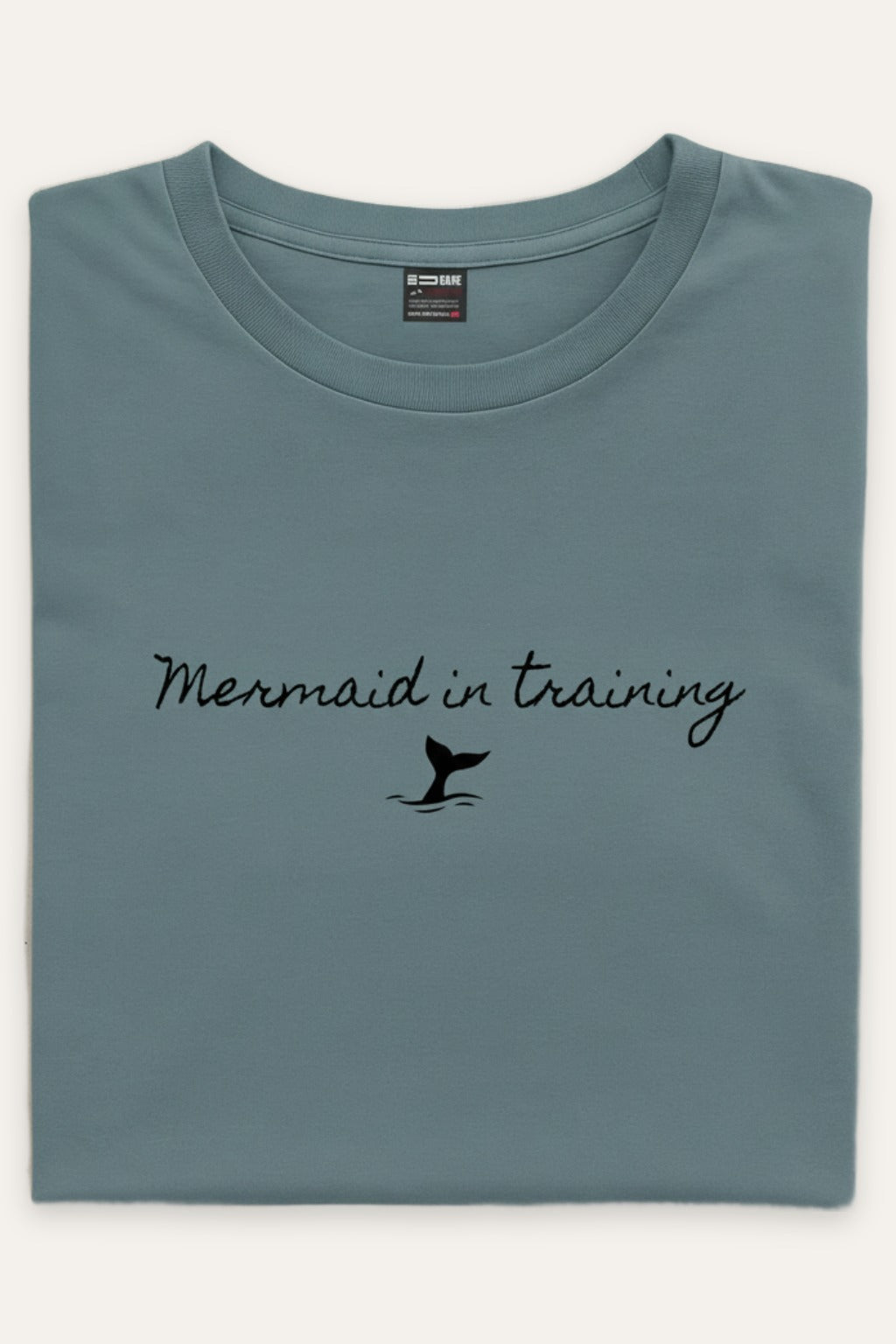 Sammenbrettet Mermaid in Training t-skjorte unisex i dusty blue – viser trykket – Fjord Vibes