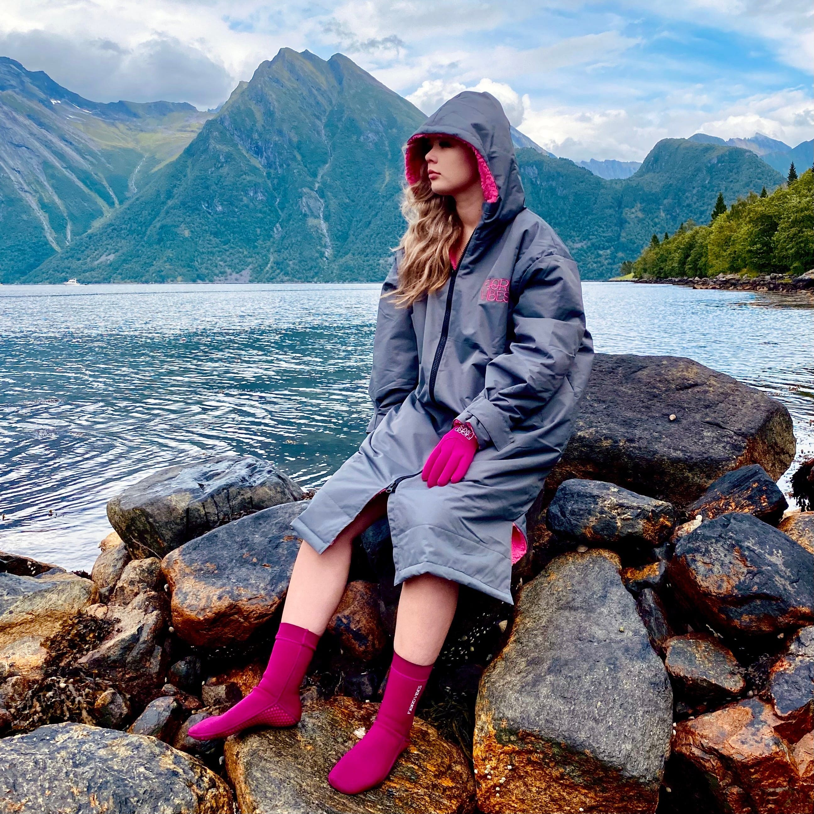 Dame som har på seg en tykk badekåpe i grått med rosa tykk fleece innside. Hun har matchende lavendel neopren hansker og Lavendel neoprensokker